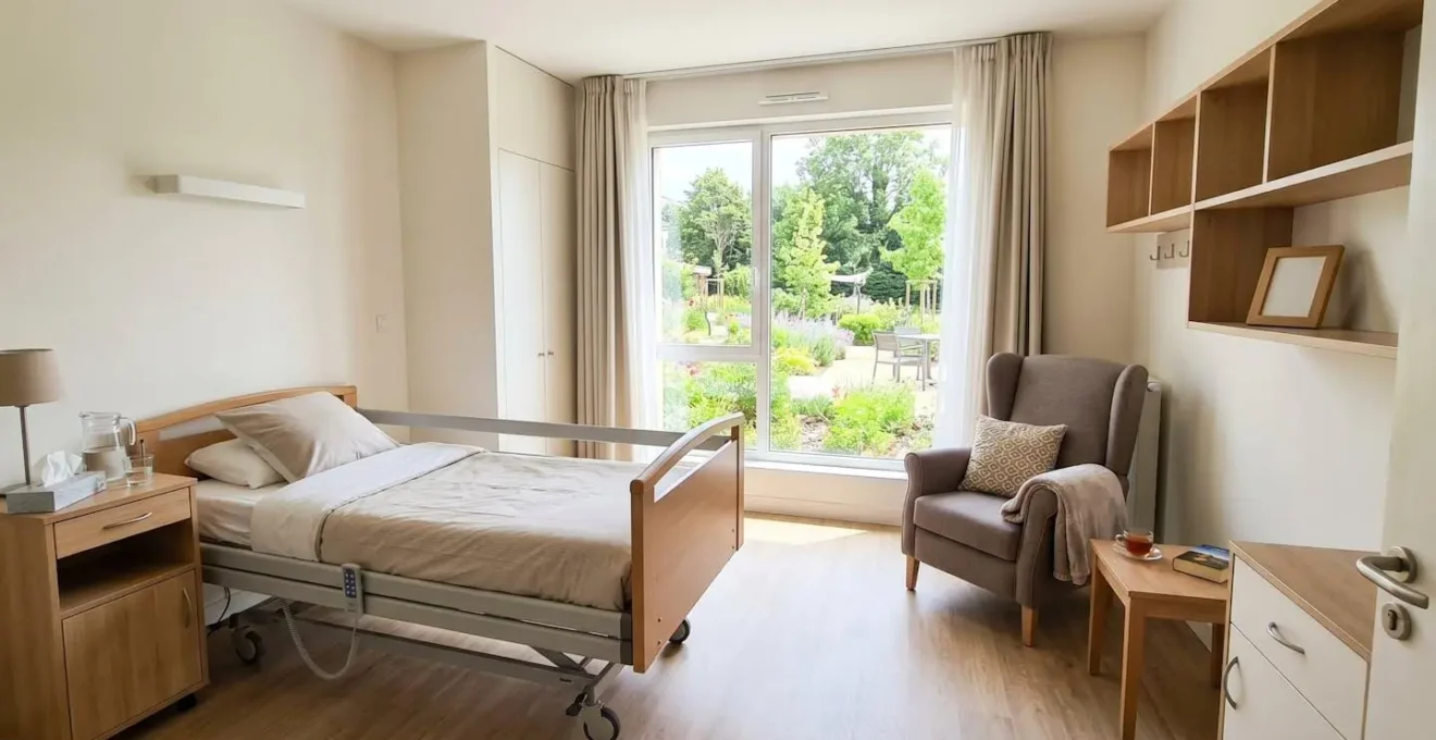 Chambre d'EHPAD contemporaine et lumineuse avec lit médicalisé, fauteuil confortable et grande fenêtre donnant sur un espace vert